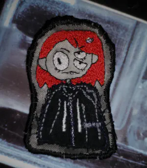 an embroidered patch depicting a character with red hair named belts