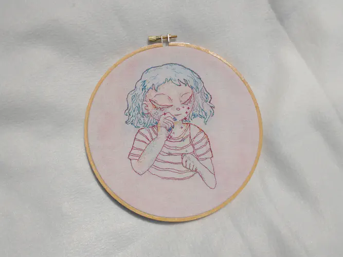 an embroidery depicting a character with blue hair crying stars 